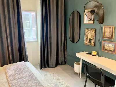 a bedroom with a bed and a desk and a mirror at Bali Style Rooftop Apartment in Bangkok