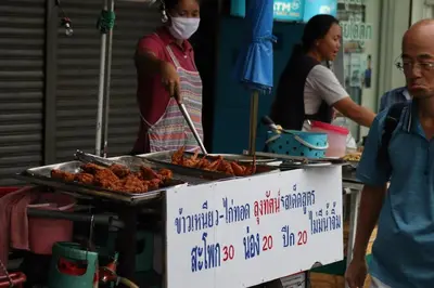 a group of people standing around a grill with food at SKY 21 Colorful Room with Soaring View Center BKK in Bangkok
