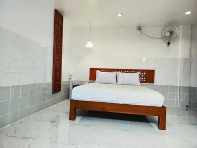 a bedroom with a bed with white sheets at Tropical Apartments 1 No Stairs easy peasy in Bangkok