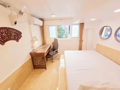 a bedroom with a bed and a desk and a window at Crane nest 2 mezzanine opaque view in Bangkok