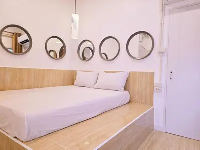 a bedroom with a bed with four mirrors on the wall at Crane nest 6 Townhouse View in Bangkok