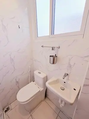 a white bathroom with a toilet and a sink at Crane nest 6 Townhouse View in Bangkok