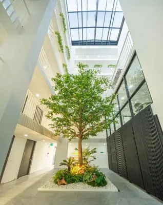 a tree in the middle of a building with windows at SHIN Patara Living Hotel in Bangkok