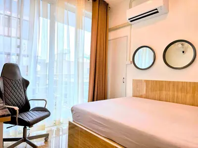 a bedroom with a bed and a chair and a window at Crane nest 8 townhouses view middle with balcony in Bangkok