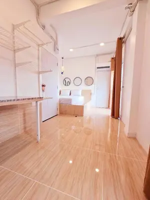 a large room with a bed and a wooden floor at Crane nest 9 palm tree villa view in Bangkok