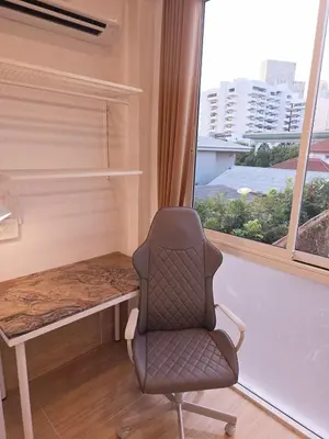 a desk and a chair in a room with a window at Crane nest 10 banana farm view in Bangkok