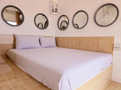 a bedroom with a bed with three mirrors on the wall at Crane nest 12 mansion view in Bangkok
