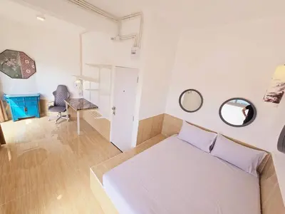 a bedroom with a bed and a desk and a chair at Crane nest 12 mansion view in Bangkok