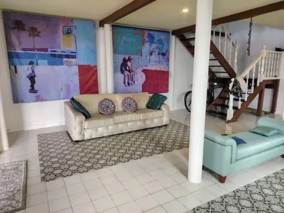 a living room with a couch and a staircase at Sabai Sabai House Koh Kret in Ban Laem Yai