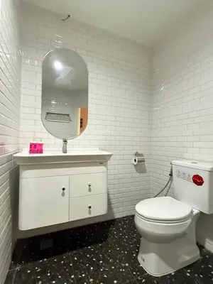 a bathroom with a white toilet and a mirror at Luck Hotel Huai Khwang MRT Ratchada in Bangkok