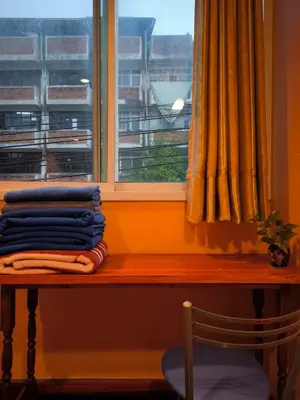 a window with a pile of towels on a table next to a window at Santo house Bangkok in Bangkok