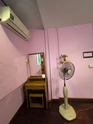 a room with a pink wall with a fan at Santo house Bangkok in Bangkok