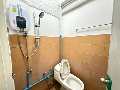 a bathroom with a toilet and a shower at Happyland Guesthouse in Bangkok
