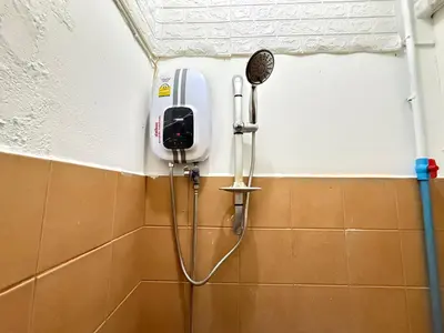 a shower in a bathroom with a hair dryer at Happyland Guesthouse in Bangkok
