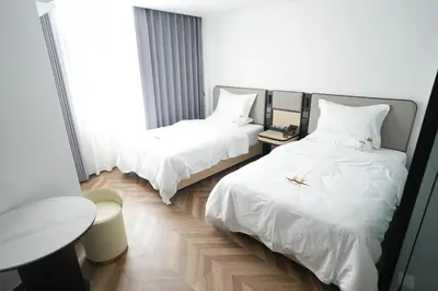 a hotel room with two beds and a table at Haiman Hotel\u6d77\u66fc\u9152\u5e97 in Bangkok