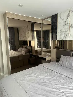 a bedroom with a bed and a large mirror at The Room Sukhumvit 64 Punnawithi in Phra Khanong