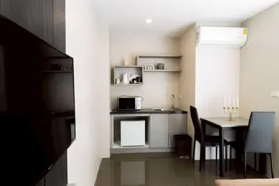 a small kitchen and dining room with a table at Dancenter Sukhumvit 107 Bangkok Hotel in Bangkok