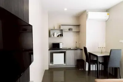 a small kitchen with a table and a microwave at Dancenter Sukhumvit 107 Bangkok Hotel in Bangkok