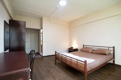 a bedroom with a bed and a table in it at Petch Tower Ekamai Budget Serviced Apartments in Bangkok