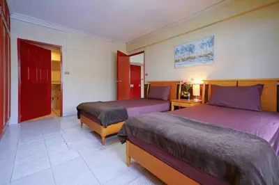 a hotel room with two beds and a red door at Petch Tower Ekamai Budget Serviced Apartments in Bangkok