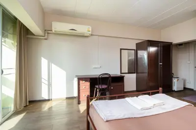 a bedroom with a bed and a dresser and a desk at Petch Tower Ekamai Budget Serviced Apartments in Bangkok