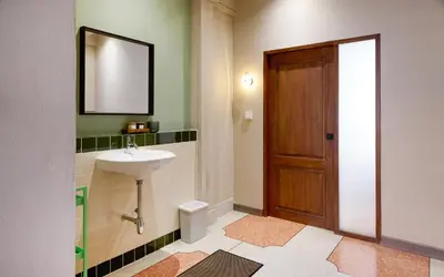 a bathroom with a sink and a wooden door at Newly Renovated, 4BR Townhouse , 5min MRT , Group in Bangkok