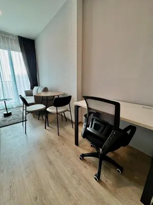 a room with a desk and a chair and a table at Luxury 1 BR Bangkok New CBD High Fl MRT Rama 9 in Bangkok