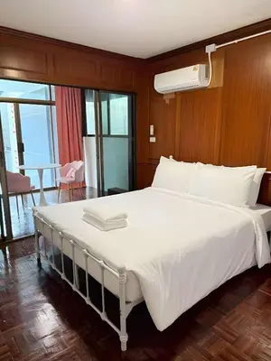 a large white bed in a room with a table at XX Stay On Sukhumvit 11 - สเตย์ออน สุขุมวิท ซอย 11 in Bangkok
