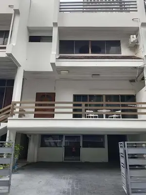 a large white building with chairs and a balcony at XX Stay On Sukhumvit 11 - สเตย์ออน สุขุมวิท ซอย 11 in Bangkok