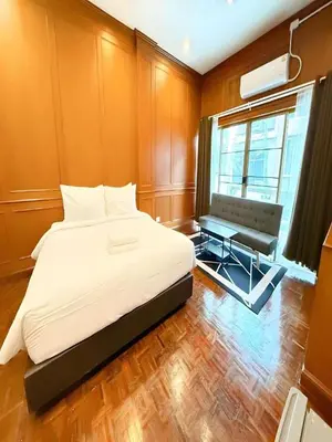 a bedroom with a bed and a bench and a window at XX Stay On Sukhumvit 11 - สเตย์ออน สุขุมวิท ซอย 11 in Bangkok