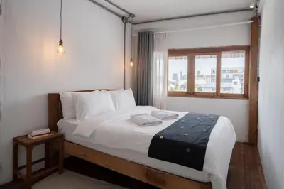 a bedroom with a large bed with a window at Urban Nest Townhouse, Local-feel, Roof,Nightmarket in Bangkok