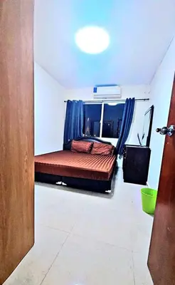 a bedroom with a large bed with blue curtains at River View 9 in Bangkok