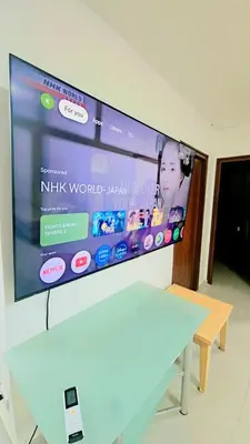 a flat screen tv on a wall with a table at River View 9 in Bangkok