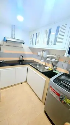 a kitchen with white cabinets and a sink and a stove at River View 9 in Bangkok
