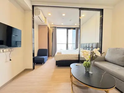 a living room with a couch and a bed at The Prestige Suites Rama 9 in Bangkok