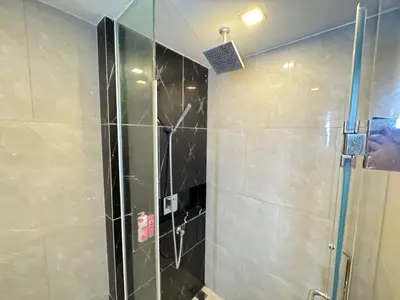a shower with a glass door in a bathroom at The Prestige Suites Rama 9 in Bangkok