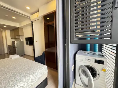 a bedroom with a washing machine in a room at The Prestige Suites Rama 9 in Bangkok