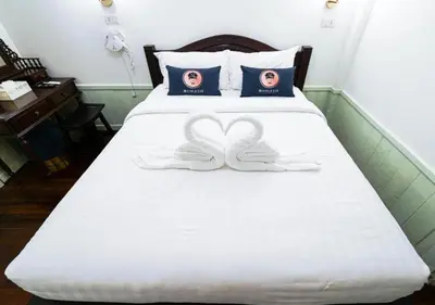 a bed with two peace signs on it at RQ Timeless Dinsor Cultural Heritage House in Bangkok