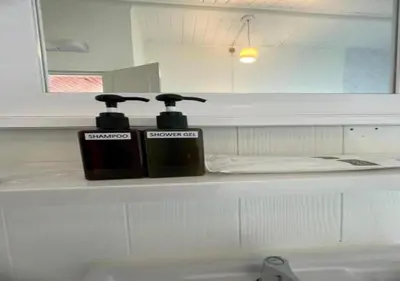 two bottles ofodorizers sitting on a counter in a bathroom at RQ Timeless Dinsor Cultural Heritage House in Bangkok