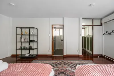 a white room with two beds and a doorway at MIQ S22 Pool Villa PhromPhong Emsphere 5BR in Bangkok
