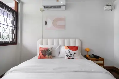 a bedroom with a bed with white sheets and pillows at MIQ S22 Pool Villa PhromPhong Emsphere 5BR in Bangkok