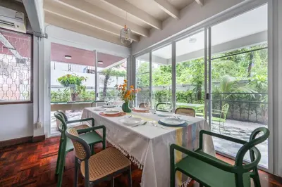 a dining room with a table and chairs and windows at MIQ S22 Pool Villa PhromPhong Emsphere 5BR in Bangkok