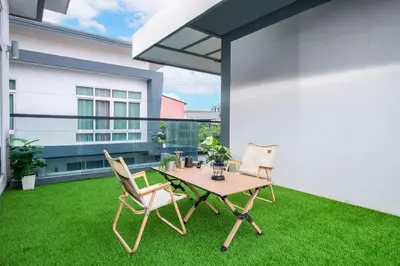 a patio with a table and chairs on the grass at Luxury Pure Modern Pool Villa 5Bed KTV Gym Nr BTS&Central in Bangkok
