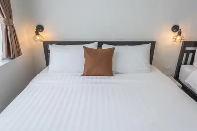 a bed with white sheets and pillows in a room at The Urban478 Modern&Cozy Stay in Bangkok