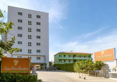 a large white building in front of a building at Townhouse Siam Privi Hotel in Bangkok