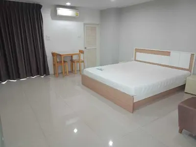 a bedroom with a bed and a table and chairs at Townhouse Siam Privi Hotel in Bangkok