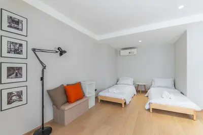 a white room with two beds and a chair at Heaven Thonglor 36 - Villa in Bangkok