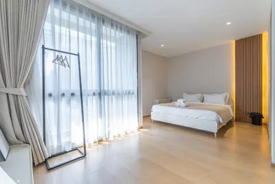 a bedroom with a bed and a large window at Heaven Thonglor 36 - Villa in Bangkok