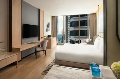 a hotel room with a bed and a television at Grand Nikko Bangkok Sathorn in Bangkok