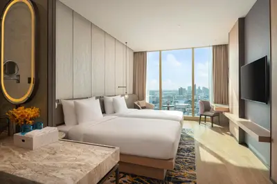 a bedroom with a large white bed and a television at Grand Nikko Bangkok Sathorn in Bangkok